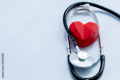 Stethoscope embracing red heart symbolizing healthcare, cardiology and medical services