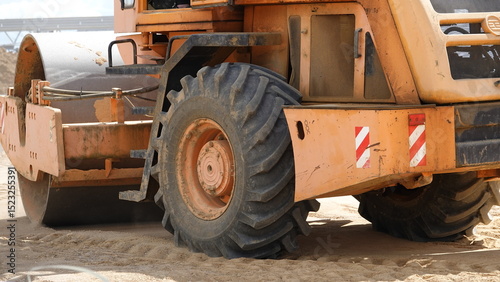 A road roller tamping down sand. Road roller during construction of a highway, freeway.