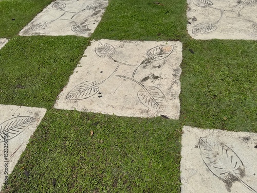 Chequered floor, alternating between concrete tiles and grass patch Malacca, Malaysia. 