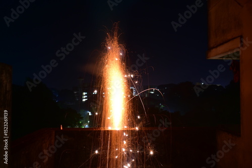 A dazzling firework fountain erupts with bright sparks in the dark.