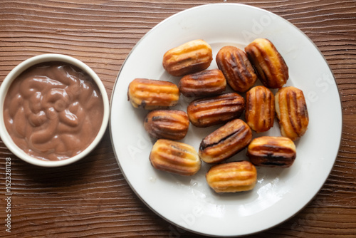 Close-up of churros dessert on a white vintage plate and hot chocolate