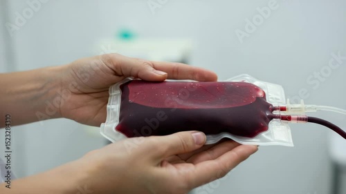 Blood bag held by hands in healthcare environment close up, World Blood Donor Day Concept