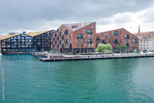 Stylish modern buildings of Kroyers Plads complex in Copenhagen, Denmark. Scandinavian apartments in houses made from red brick on the canal waterfront with space for water transport and swimming. photo
