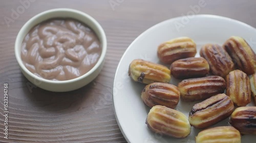 Close-up of churros dessert on a white vintage plate and hot chocolate