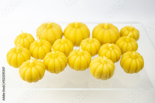 A group of beeswax Halloween yellow pumpkin candles isolated on white background