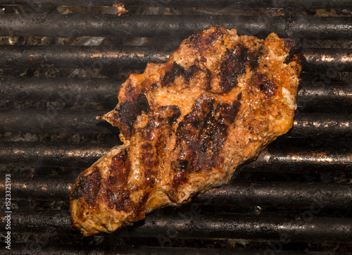 Roasting meat on the grill. Cooking fast food (barbecue) outside.