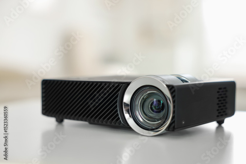 Modern video projector on white table indoors, closeup