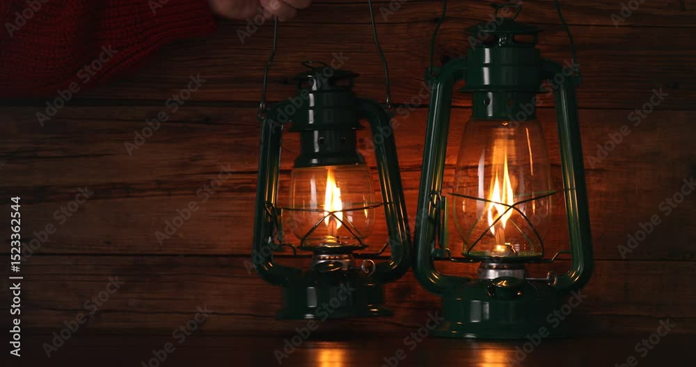 Man putting kerosene lamps on wooden table, closeup