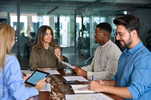 Diverse business team people in office. Happy middle aged female executive leader discussing project management planning strategy working with colleagues at office corporate board group meeting.