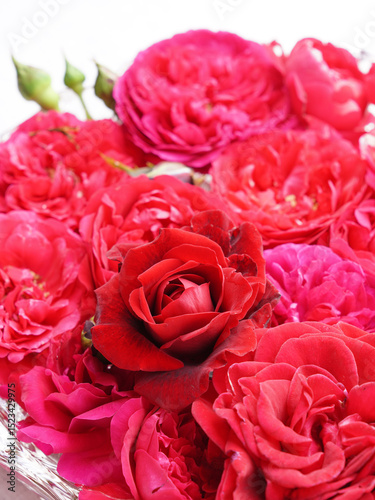Red roses on water in glass bowl.