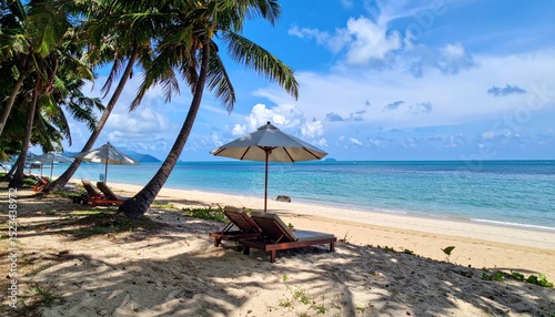 Idyllic tropical beach scene with lounge chairs and parasols under palms
