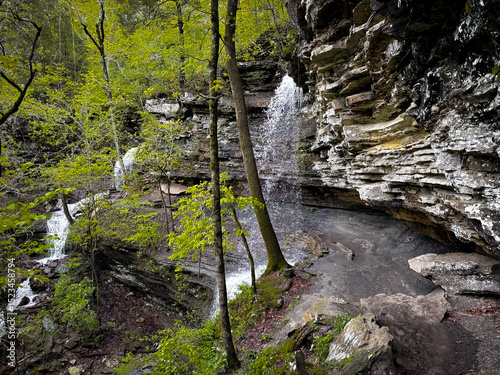 Twin Falls waterfall at Devil’s Den State Park in Arkansas  cascading over natural sandstone ledges in a lush forest trail setting in the Ozark Mountains