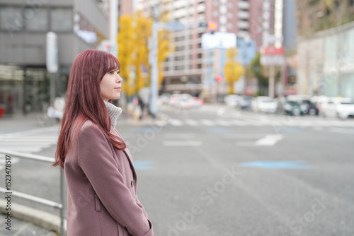 Canvas Print On a cold December morning, a Japanese woman in her early twenties with long pink hair, wearing a stylish pink trench coat, walks gracefully through a beautifully clean, calm, and modern city street
