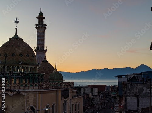 A silhouette of the mosque with the mountain behind in the morning