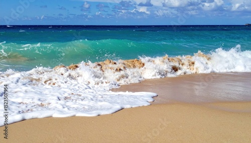 Splashing turquoise wave rolls onto a golden sand beach under a blue sky