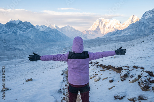 Happiness tourist raised her arms when facing Himalayas range while she climbing Kalapathar viewpoint in the morning.