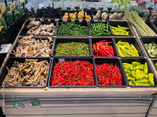 RAYONG, THAILAND - JUNE 1, 2025 : Fresh organic vegetables in basket for selling in the supermarket. chilli, ginger, galangal, lemon grass, finger root