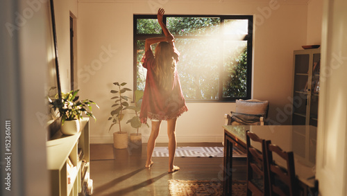 Back, woman and stretching by window for good morning, freedom and ready to start day in house. Home, sunshine and person with view for wake up, flare and fresh with energy on weekend with peace