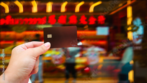Investors holding credit cards in front of gold shops in Chinese communities, highlighting the convenience of investing and the privileges of credit cards.