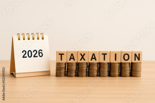 Taxation concept illustrated with calendar blocks and coins on a wooden surface. This image visually represents the financial implications of taxation in the year 2026