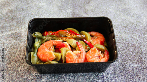 Tumis Udang or Stir tomato Prawns with chili and oyster sauce as Asian food. Served on white blox. Selective focus photo
