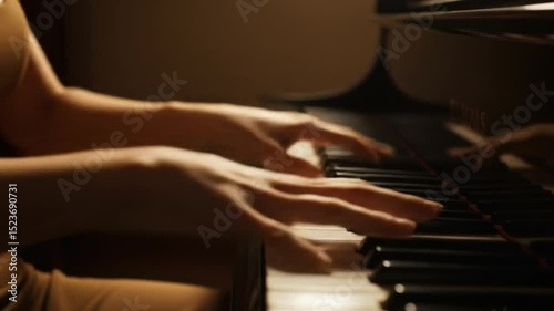 Hands playing piano in soft light