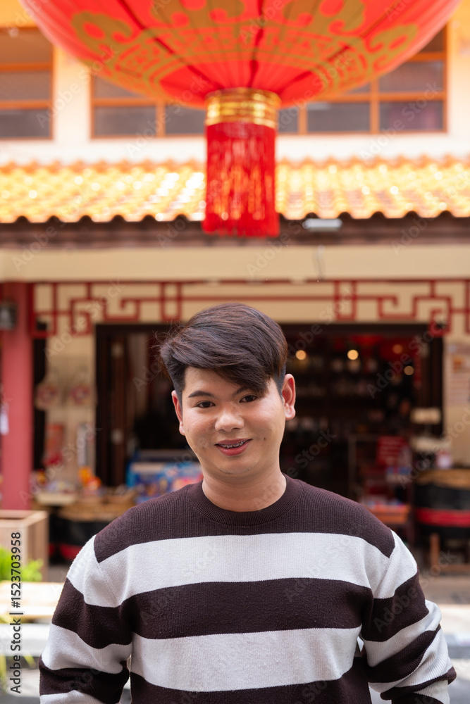 Fototapeta premium Young gay man in Chinese garden outdoors market