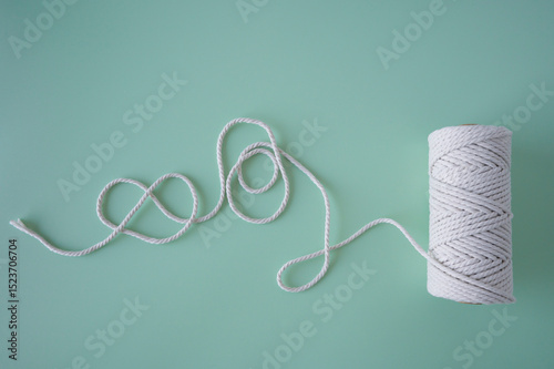 Twisted cotton string unwinds on mint backdrop