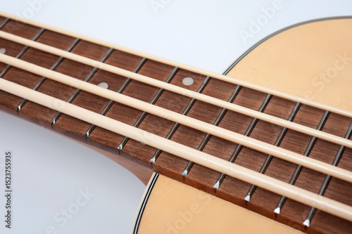 Four-string bass ukulele with wooden body and built-in tuner and pickup.