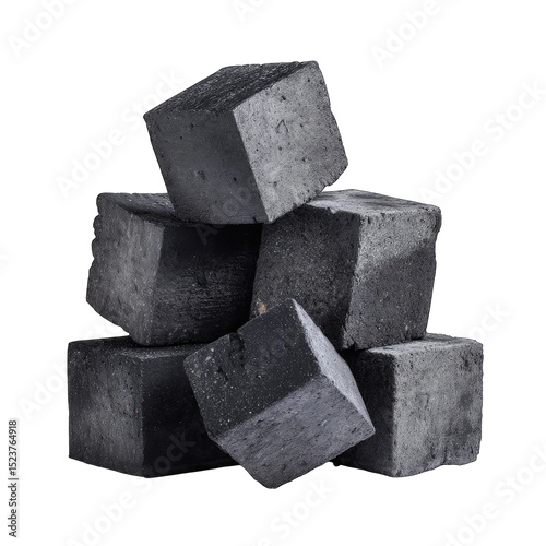 Dark grey, cubic charcoal briquettes stacked in a loose pyramid