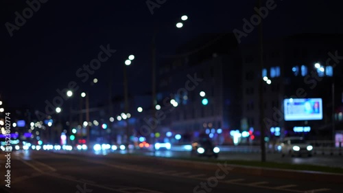 Evening traffic on a city highway: dynamic footage captured from the roadside. Cars flow in motion, with headlights and urban lights creating a vibrant atmosphere