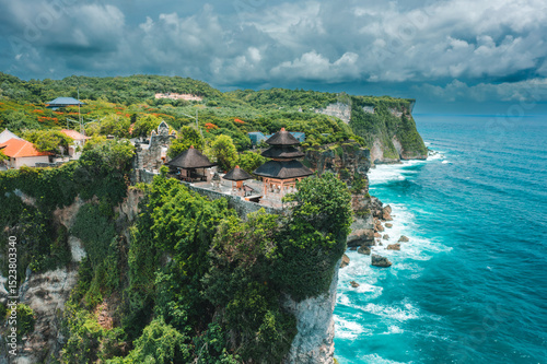 Bali's Most Iconic Landmark and popular tourist attraction Uluwatu Temple one of six key Bali temple perched on top mountain cliff on background amazing nature Bali, Indonesia Aerial view