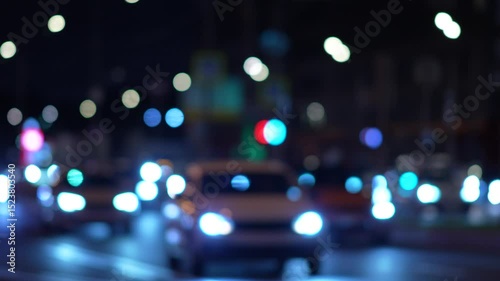 Evening traffic on a city highway: dynamic footage captured from the roadside. Cars flow in motion, with headlights and urban lights creating a vibrant atmosphere