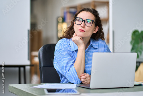Serious professional business woman employee or student using laptop. Thoughtful lady looking away thinking of question or idea, working or learning on computer feeling doubt, at home or in office.