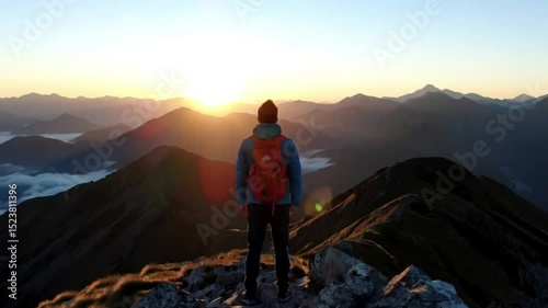 Aerial view of a man traveler on top of a mountain looking at the sunrise, celebrating scenic landscape enjoying nature vacation travel adventure