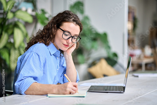 Foto Female employee watching online webinar training, doing research, managing work tasks sitting at desk in office