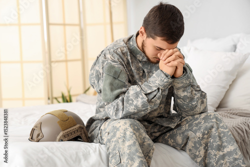 Young male soldier praying ...