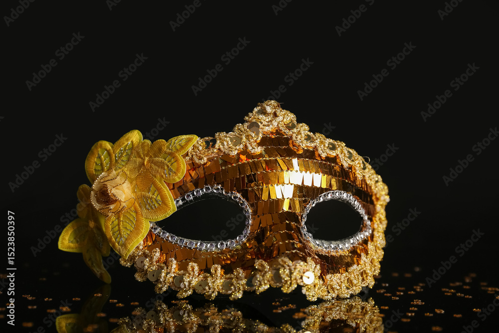Naklejka premium Golden carnival mask on black background