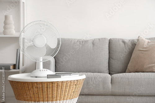 Modern electric fan on coffee table at home