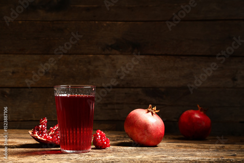 Fototapeta Naklejka Na Ścianę i Meble -  Glass of fresh pomegranate juice and fruits on wooden background