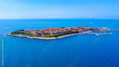 Panoramic aerial view of Old Nesebar on the Bulgarian Black Sea coast. Ancient churches and wooden houses appear over a rocky peninsula, reflecting over 3,000 years of layered Thracian, Greek and Byza