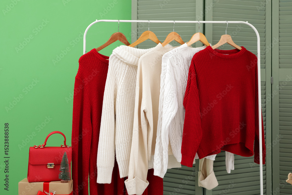 Obraz premium Rack with sweaters in hallway decorated for Christmas