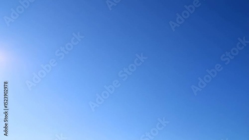 A person flying a kite in the sky over a field of grass with a bowl of peanuts and nuts on a wooden table.