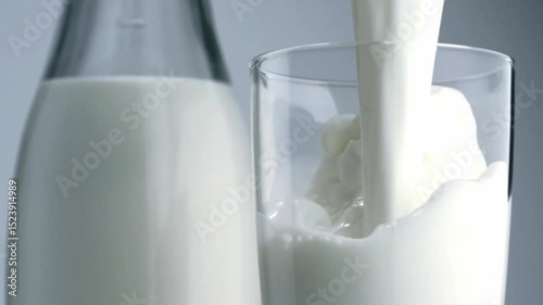 Pure white milk poured in glass and glass bottles