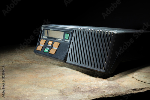 Fototapeta Naklejka Na Ścianę i Meble -  VHF ham radio sitting on a rock with a black background with copy space.