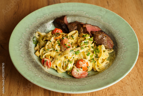 Konstfotografi Creamy tagliatelle with grilled steak and cherry tomatoes