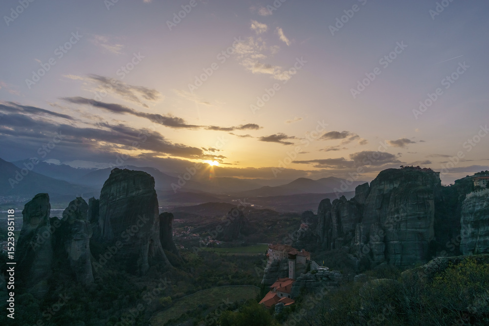Fototapeta premium Landscape of rock formations of Meteora with Roussanou and Agios Nikolaos Monasteries on top of rocks during sunset, Kalambaka, Thessaly, Greece