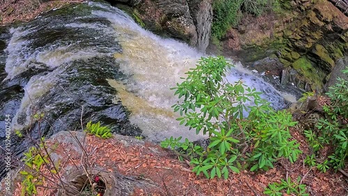 Water falls down in the mountains against the background of green vegetation, Bushkill Falls, Pennsylvania
