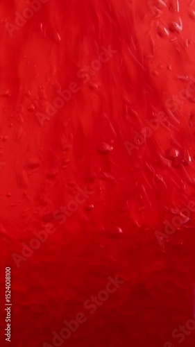Dynamic red paint flow against dark background. Premium abstract art footage showing rich crimson liquid creating mesmerizing patterns with smooth gradient transition effects.
