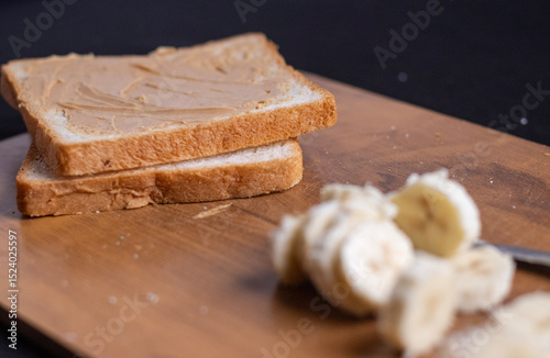 Photo of, A slice of artisanal sourdough bread with a thick spread of creamy peanut butter, Minimalist kitchen counter setting